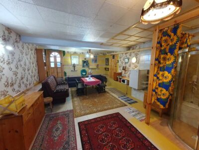 Pokój z wieloma dywanami, prysznicem, dwoma kanapami, stołem, krzesłami, lodówką i mikrofalówką.